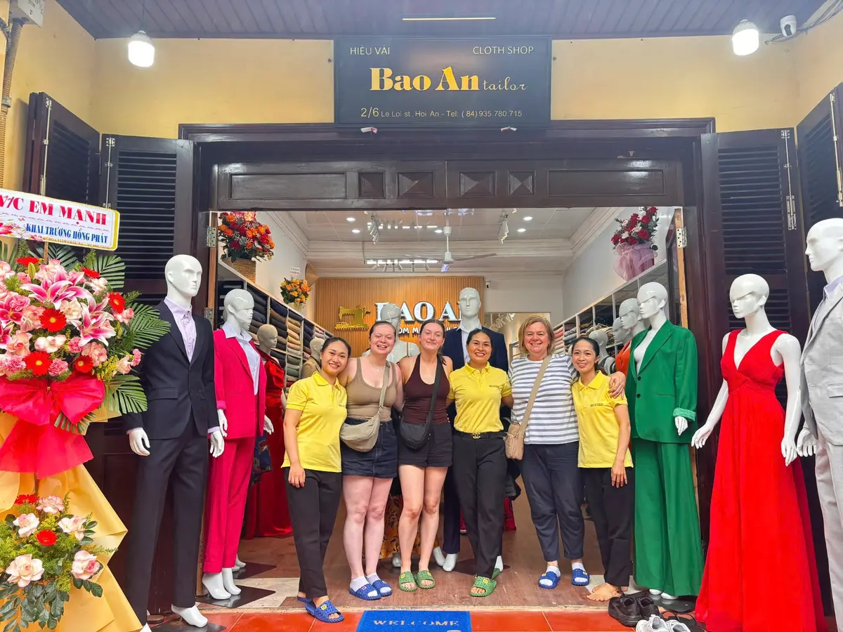 Guests and Bao An Tailor team members outside the Le Loi atelier